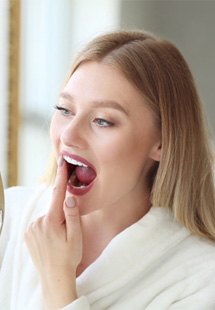 a person holding their cheek due to tooth pain